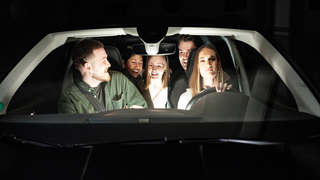 Fünf junge Menschen im fahrenden Pkw bei Nacht