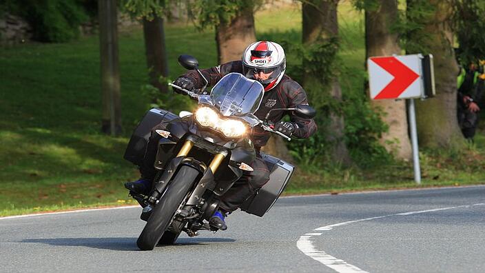 Ein Motorradfahrer fährt um die Kurve einer Landstraße