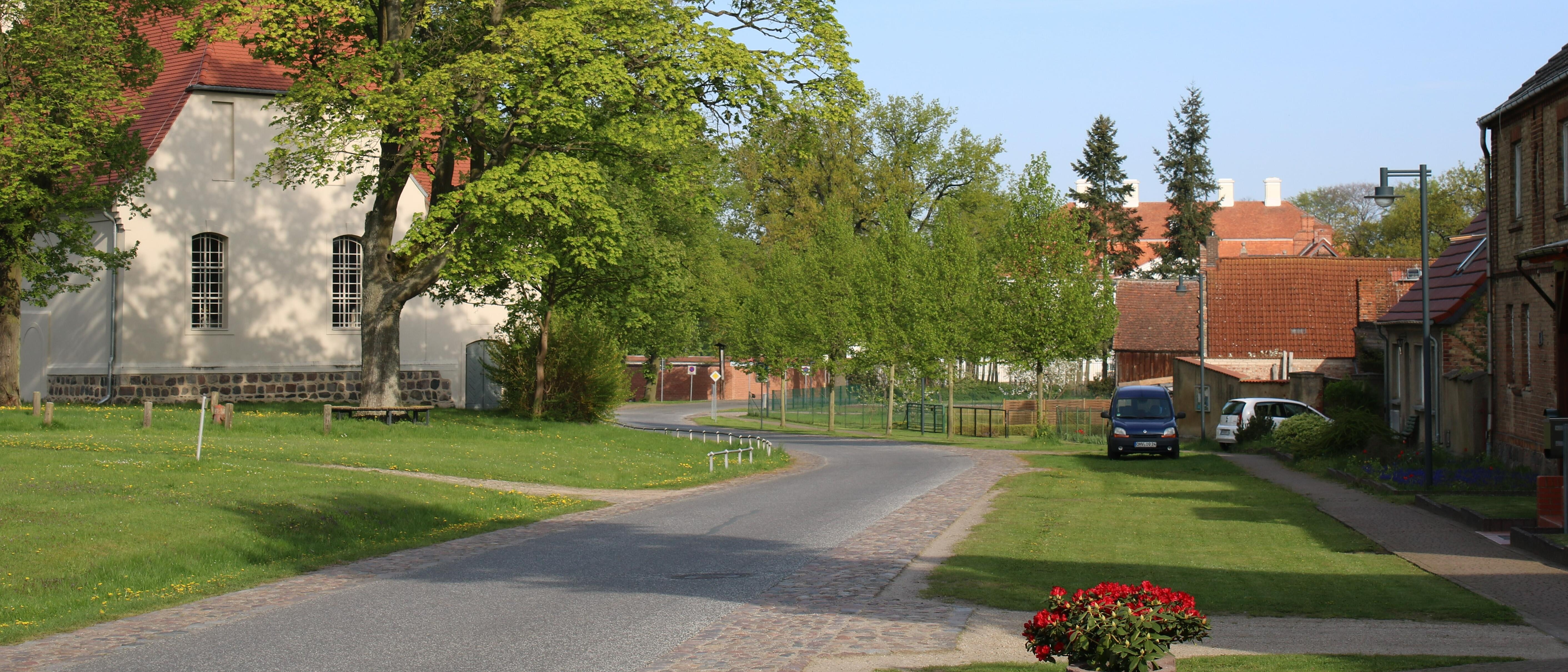 Bild 1: Die Dorfstraße nach dem Umbau: dem Dorfgrundriss und Verkehrsaufkommen angepasste Linienführung und Dimensionierung der Geh- und Fahrflächen, durch Versickerungsmulden abgesetzt