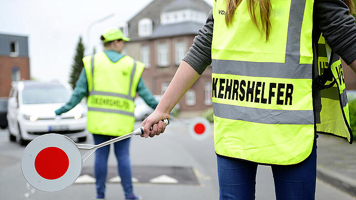 Zwei Schülerlotsen in Uniform sichern einen Übergang