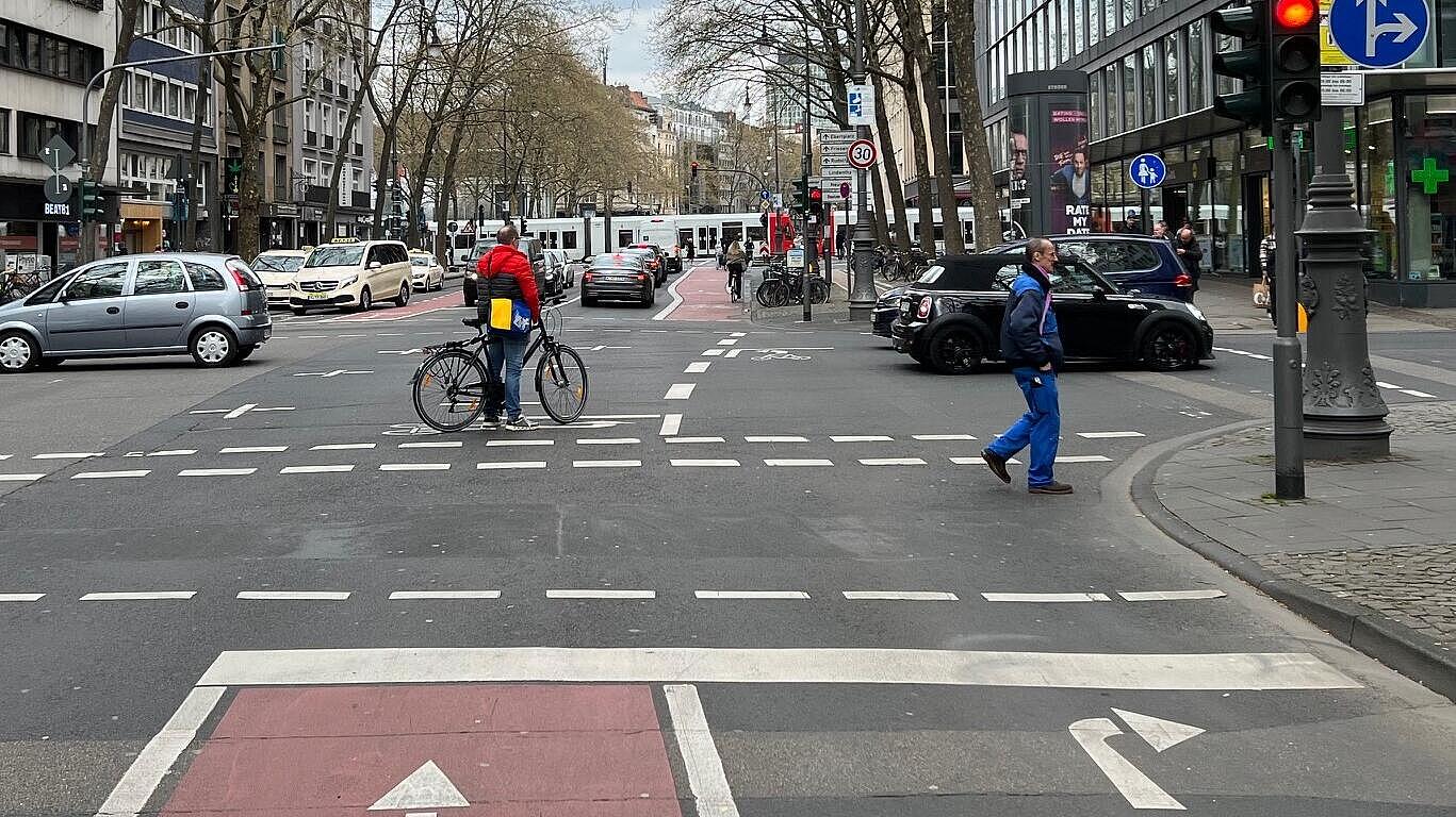 Radverkehrsführung in Knotenpunkten: markierte Aufstellfläche in Kreuzungsmitte für aus der Seitenstraße linksabbiegende Radfahrende