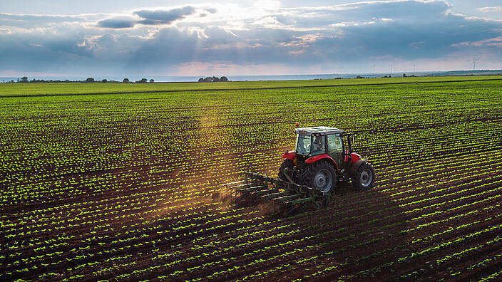 Tractor cultivating field at spring