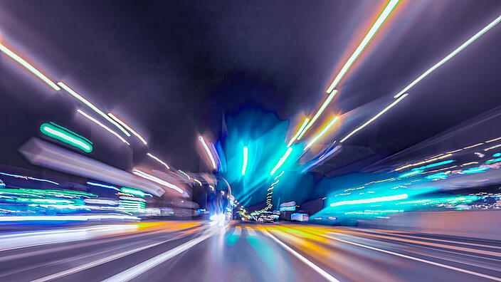 City colorful night lights perspective blurred by high speed of the car. A streak of light, trails.