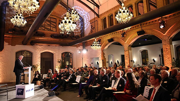 Blick in die Wartehalle Berlin. DVR-Präsident Manfred Wirsch auf der Bühne und spricht zum Publikum.