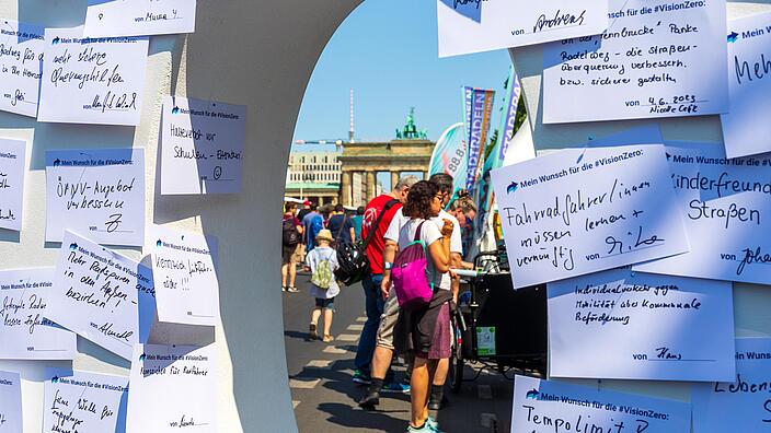 Blick auf das Brandenburger Tor durch eine große Holznull mit angepinnten Karten.