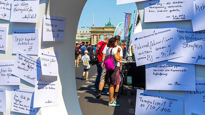 Blick auf das Brandenburger Tor durch eine große Holznull mit angepinnten Karten.