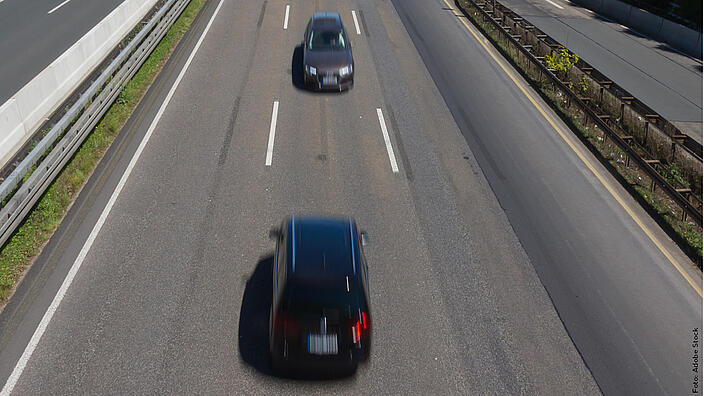 Auf einer Autobahn fährt ein Auto einem anderen entgegen.