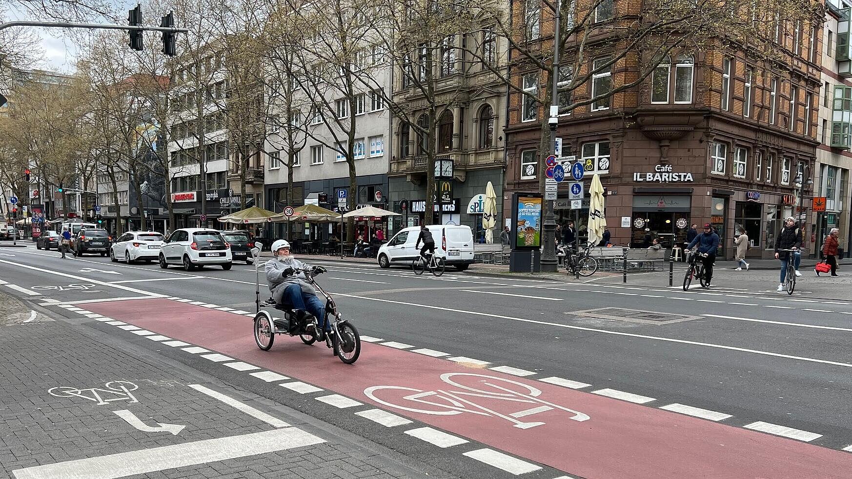 Quer verlaufende Nebenachse des Radverkehrs: eigene Radverkehrssignalisierung mit kurzen, auf der Außenseite neben den Radfahrstreifen angeordneten Aufstellflächen für den vom Habsburger Ring auf die Achse abbiegenden Radverkehr