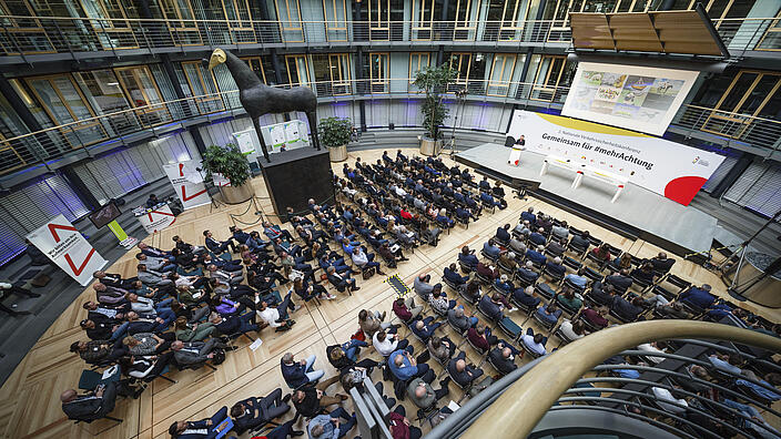 Blick von oben auf das Publikum in den Veranstaltungsraum. 