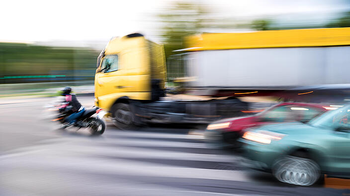 Dangerous city traffic situation with a motorcyclist and a truck