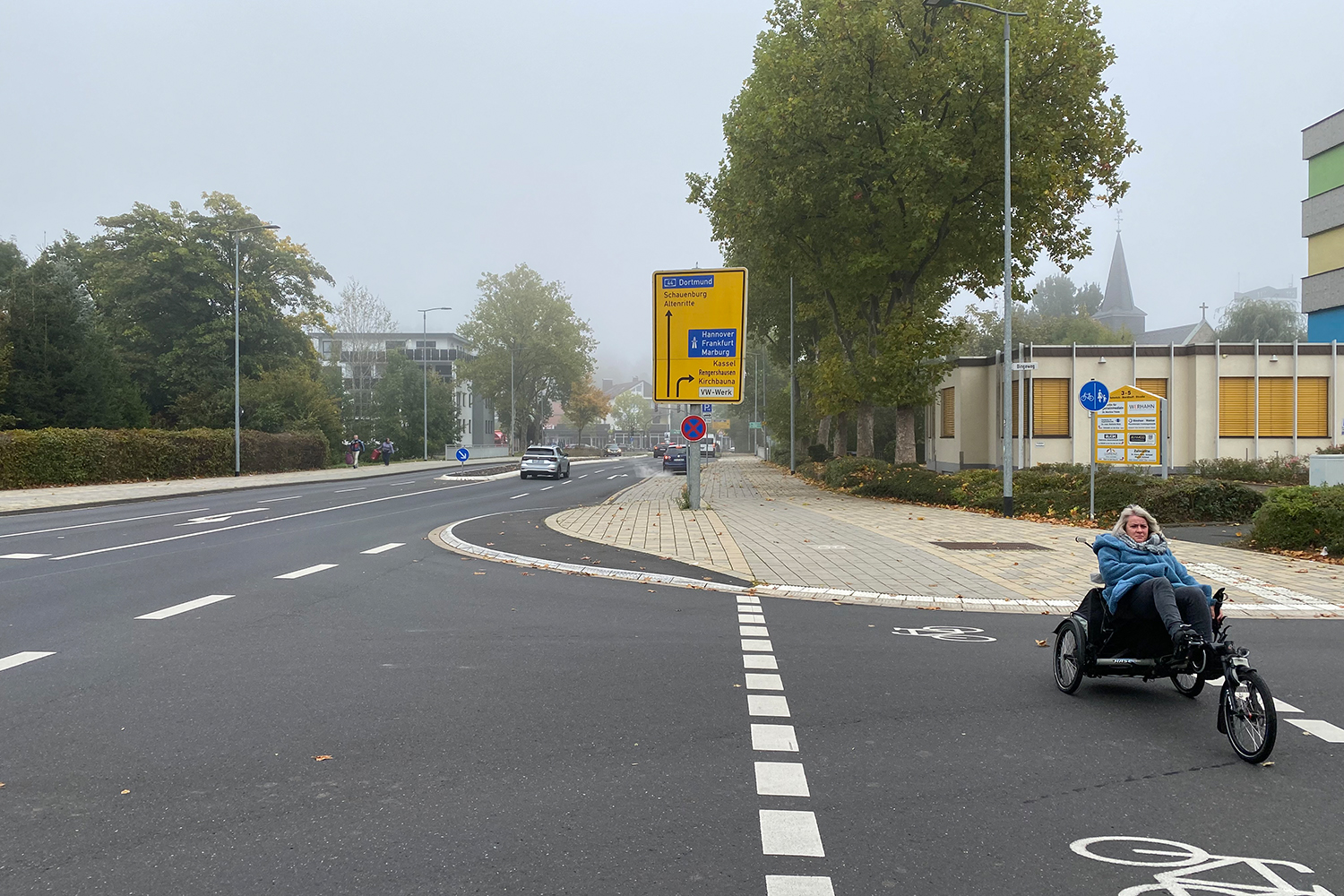 Bild 23: Gestaltungsdetail: Die im Seitenraum asphaltierte, „selten befahrene Fläche“ in der Ausfahrt aus dem Bingeweg in die Heinrich-Nordhoff-Straße ist auf Grundlage der Schleppkurven von Schwerverkehrsfahrzeugen konstruiert und dient nicht zuletzt dazu, dass der Linksabbiegestreifen in der Hauptverkehrsstraße nicht zurückgezogen markiert werden musste.