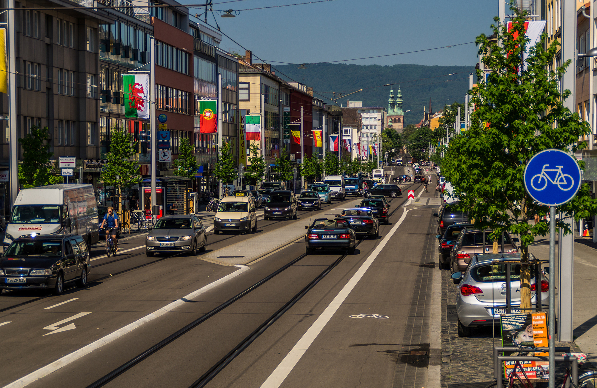 Realisierung eines vergleichbaren Gestaltungsprinzips: Die später umgestaltete Friedrich-Ebert-Straße weist eine vergleichbare Querschnittsgestaltung auf mit integrierter Führung von Straßenbahn und Kfz-Verkehr auf gleicher Fahrbahn wie auch eine gleiche Gestaltung der Straßenbahnhaltestellen mit angehobener Radverkehrsführung im Bereich der Kaps – die fertiggestellte Straße.