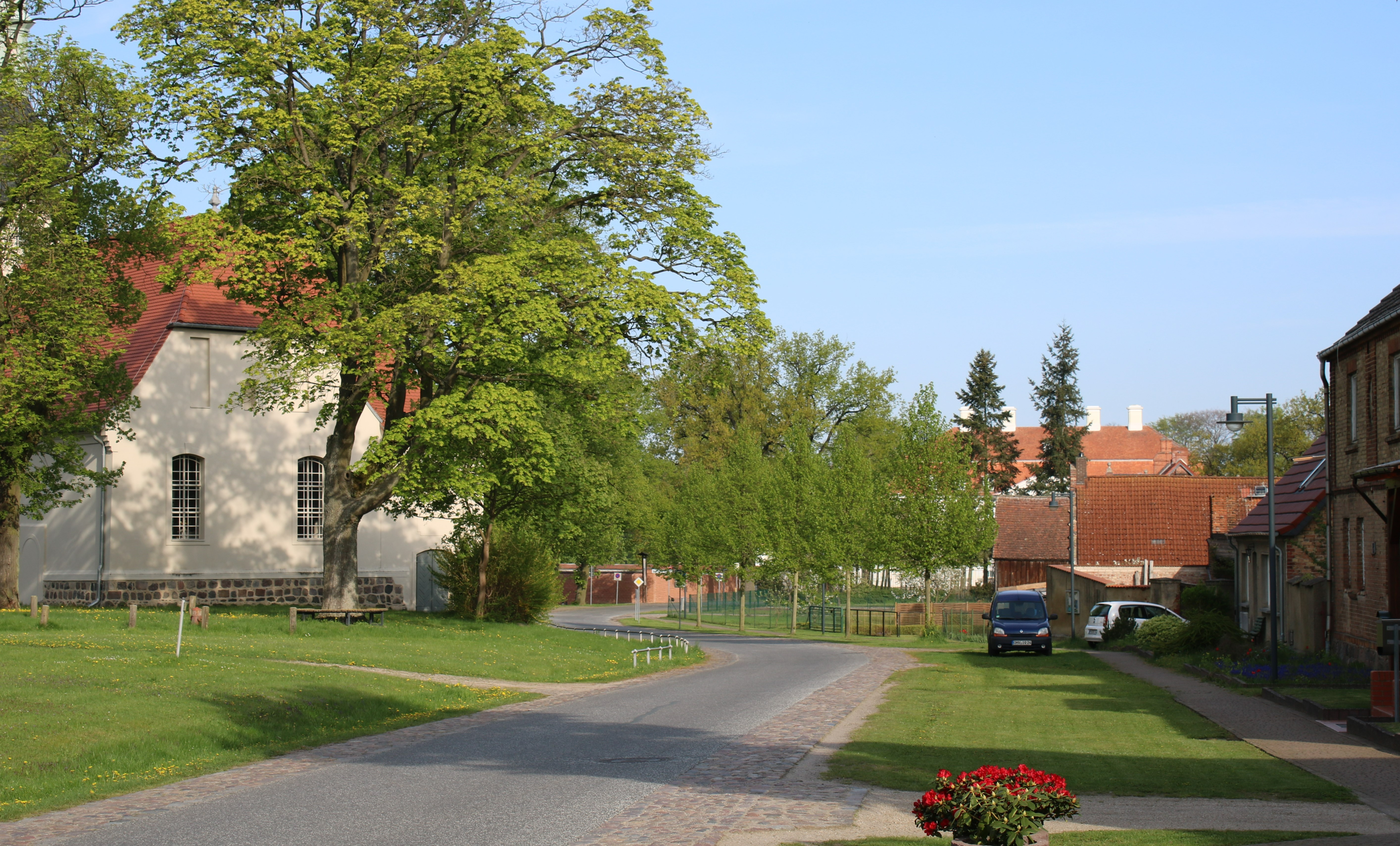 Bild 1: Die Dorfstraße nach dem Umbau: dem Dorfgrundriss und Verkehrsaufkommen angepasste Linienführung und Dimensionierung der Geh- und Fahrflächen, durch Versickerungsmulden abgesetzt