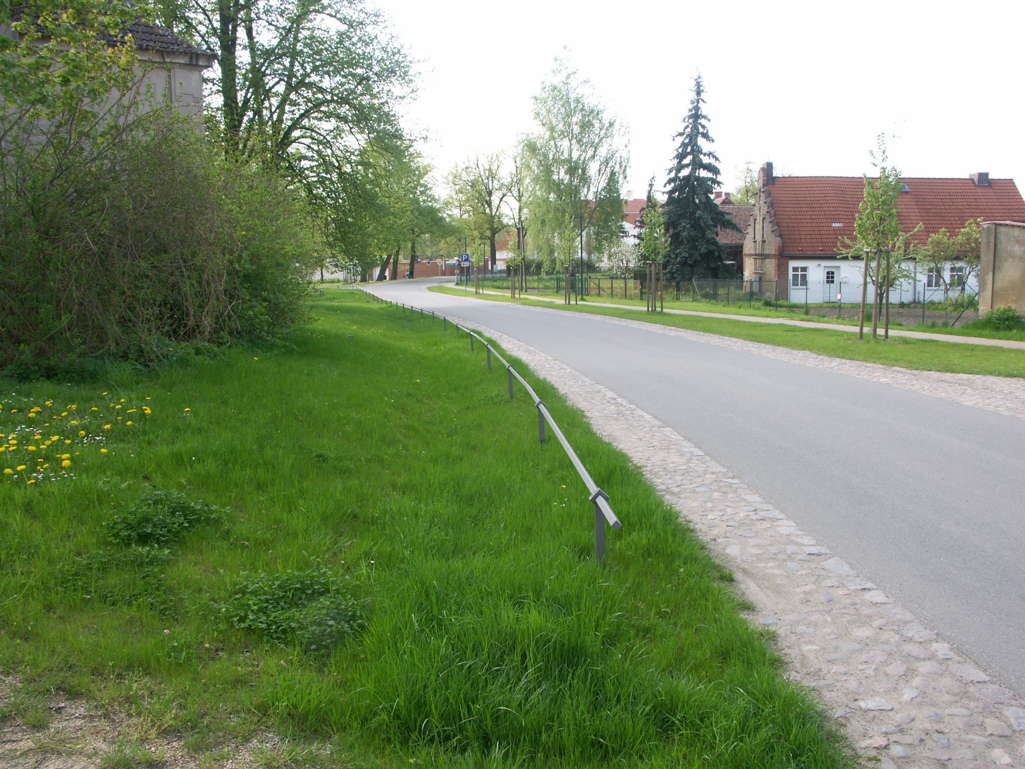 Bild 10: Fahrbahngestaltung innerorts: schmale Asphaltfahrbahn mit beidseitig begleitenden Pflasterstreifen prägen die dörfliche Situation