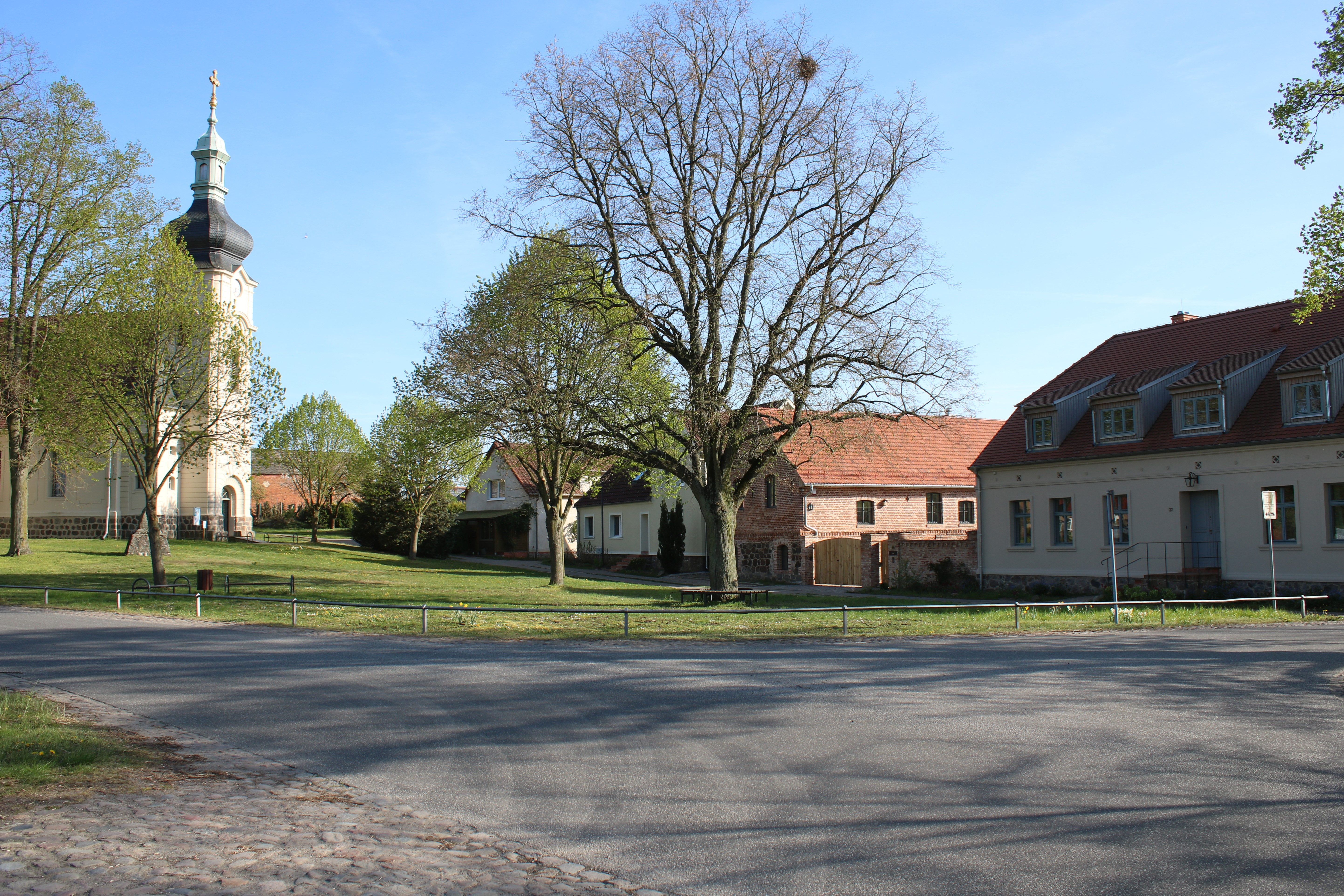 Bild 18: Dorfstraße am Anger: dezente Anpassung der Straßenraumgestaltung an die dominante städtebaulich-räumliche Situation von Angerfläche, Dorfkirche und angrenzender Bebauung